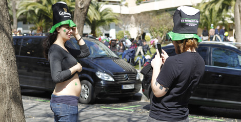 Una mujer ensea orgullosa su barriguita con trbol. | Jordi Soteras