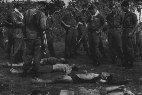 Varios 'marines' observan cadveres de vietcongs durante la Guerra de Vietnam. | E. M.
