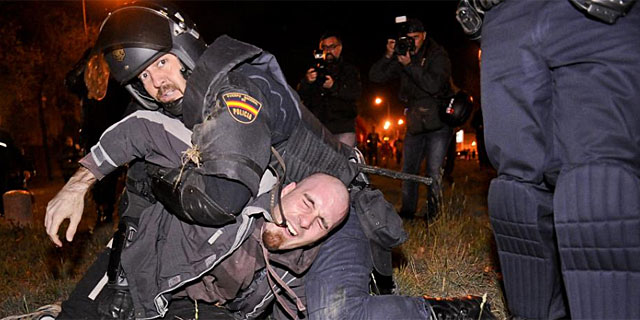 Un agente detiene a uno de los manifestantes en las cocheras de Fuencarral. | G. Arroyo