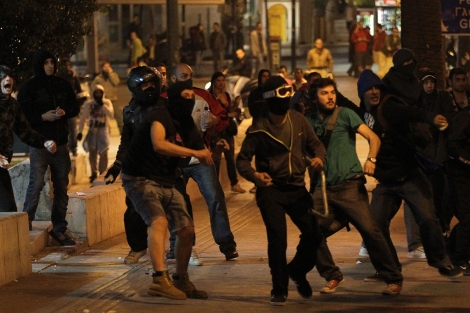 Manifestantes griegos lanzan piedras contra la polica en Atenas. | Efe