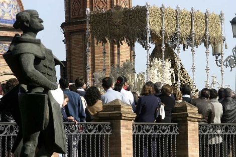 La estatua de Belmonte en Triana mira a la Maestranza mientras pasa la Virgen de la Esperanza.