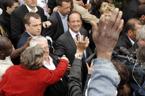 El candidato socialista, Francois Hollande (centro), rodeado de seguidores en Les Ulis, un barrio de las afueras de París. | Reuters