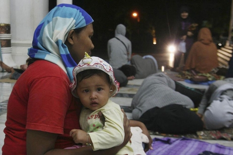 Una mujer y su hija, junto a otros evacuados, en Aceh (Indonesia). | Reuters