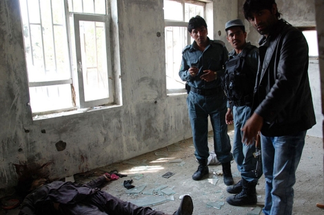 Policas afganos al lado de uno de los talibn abatido en el edificio en construccin. | M. B.