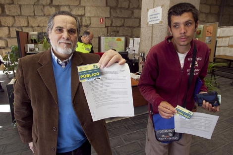 Dos ciduadanos muestran su acreditacin para acceder al pleno. | Madero Cubero