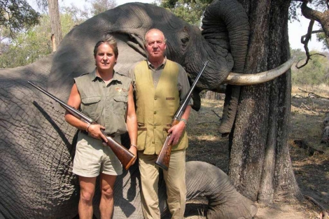 El rey posa con un elefante abatido en Botsuana junto al guía cinegético.
