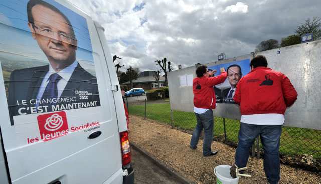 Miembros del Partido Socialista pegan carteles de su candidato en Chaulnes (Francia). | Afp