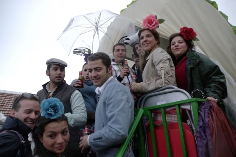 Un grupo de romeros se protege con un paraguas de la lluvia. | Manuel Cuevas