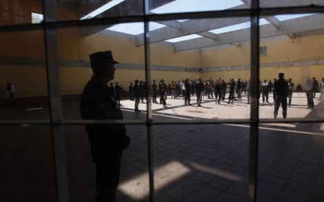 Varios policías vigilan a los internos en el patio del CIE. | Quique García