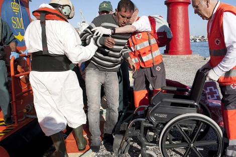 Miembros de Salvamento Martimo y la Guardia Civil ayudan a un inmigrante. | Efe