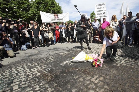 Una mujer pone flores donde se suicid Giuseppe Campaniello.| Reuters