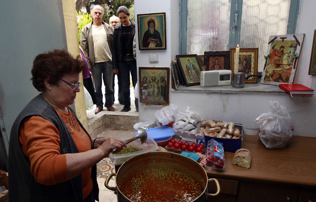 Una voluntaria prepara comida para los pobres en Atenas. | Reuters