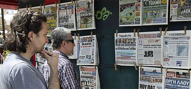 Dos griegos leen las portadas tras las elecciones.| Efe
