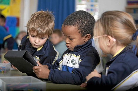 Tres niños aprenden con un iPad en el colegio Ausiàs March (Valencia).| César Conti