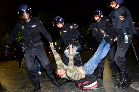 Cuatro policas desalojan a un manifestante anoche. | A. Vera