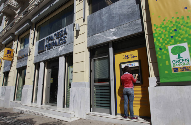 Una mujer saca dinero de un cajero en Atenas. | Reuters