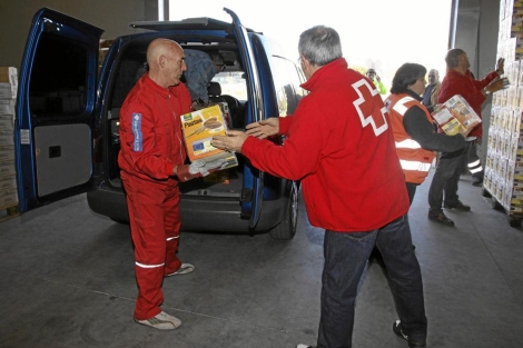 Voluntarios de Cruz Roja preparan un reparto de alimentos. | M.Brgimo