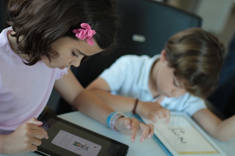 Dos nios prueban la aplicacin para iPad de Cuadernos Rubio. | C.R.