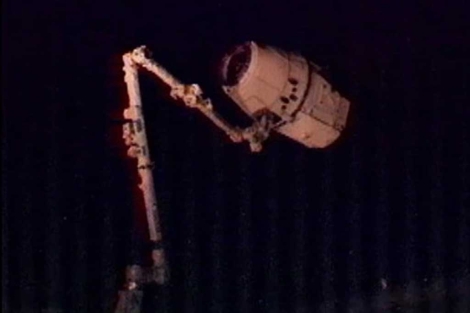 El brazo robtico sostiene la nave.| NASA