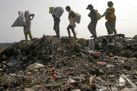 Unos nios buscan entre la basura en un vertedero de la India. | Reuters