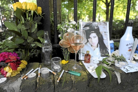 Flores, velas y mensajes depositados por sus fans cerca en la verja de Camden House. |Afp