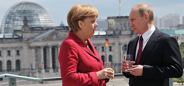 Merkel y Putin charlan, con el Reichstag de fondo.| Afp