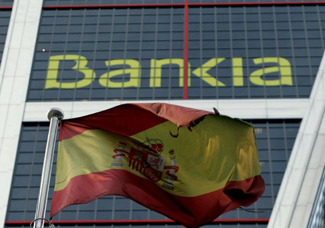 Una bandera de España ante la sede de Bankia en Madrid. | Efe