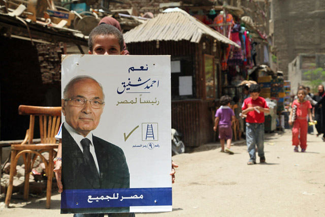 Un nio sostiene un cartel del candidato Ahmed Shafik en el barrio de los basureros de El Cairo. | Foto: F.C. .