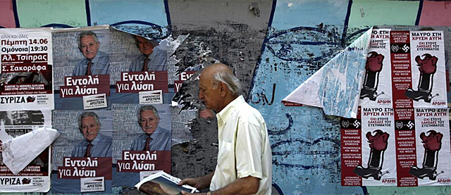 Finaliza la campaa electoral en Grecia. Un hombre camina con los cartes de fondo. | Efe