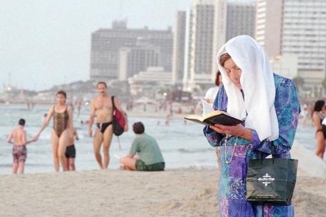 Una mujer reza en una playa de Tel Aviv. | AP