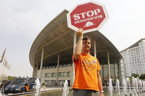 Un representante de la plataforma Stop Desahucios protesta ante el Palacio de Congresos. | Reuters