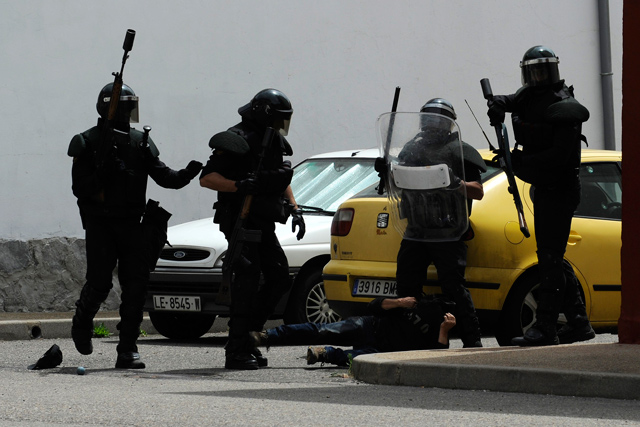 Uno de los detenidos yace en el suelo entre varios agentes. | Eloy Alonso / Reuters