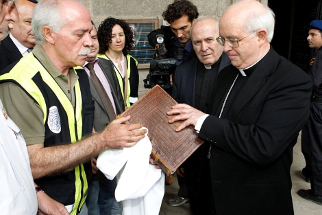 El arzobispo de Santiago (d) comprueba el estado del Cdice. | Efe/El Correo Gallego