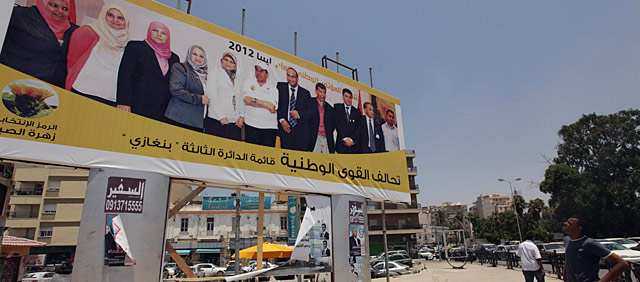 Un joven observa un cartel electoral de Yibril, este lunes en Bengasi. | Reuters