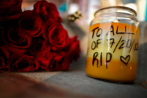 Flores y una vela en memoria de los fallecidos en la matanza de Denver. | Afp