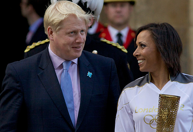 El alcalde, Boris Johnson, junto a una atleta con la antorcha olímpica.| Afp