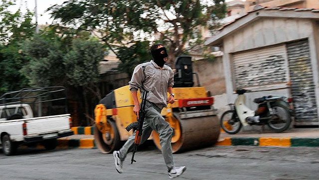 Un rebelde sirio corre en la ciudad de Aleppo. | Afp