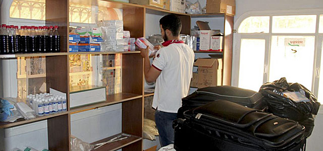 Un voluntario selecciona los medicamentos llevados clandestinamente en Siria. | Efe