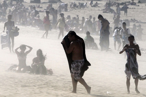Dos baistas se protegen del fuerte viento en la playa de San Sebastin. | Efe