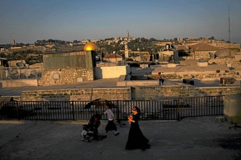 Una mujer y su hijo pasean con el teln de fondo de la Ciudad Vieja de Jerusaln. | Ap