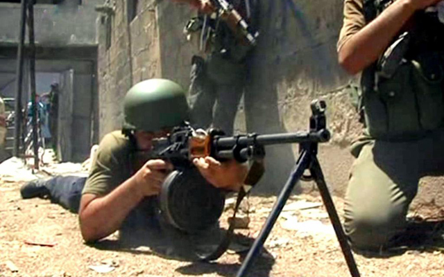 Soldados sirios durante un cruce armado con rebeldes, en una calle de Damasco. | Efe