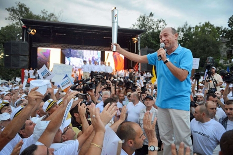El presidente Basescu, aclamado por los suyos, con la 'Llama de la Democracia'.| Afp