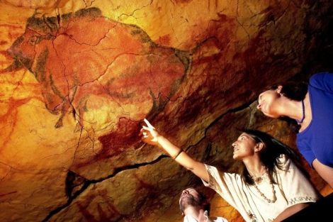 Dos turistas observan las pinturas de la cueva. | Carlos Garca