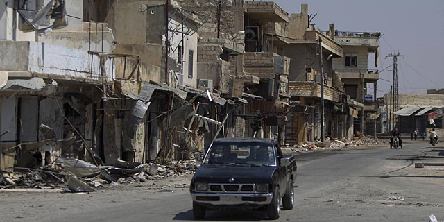 Un coche avanza por una calle de Alepo. | Afp