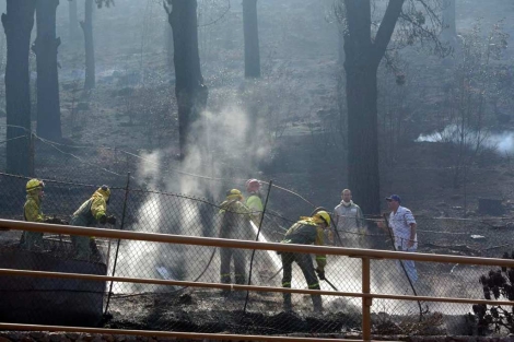 Bomberos refrescando una zona de La Gomera para evitar el rebrote de las llamas. | Efe