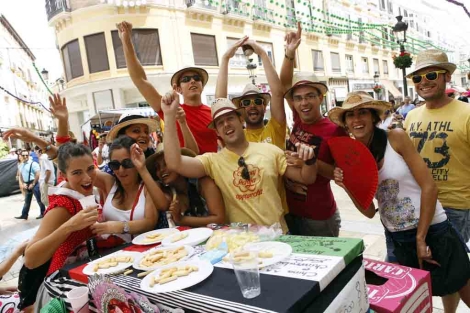 Un grupo de amigos almuerzan en una improvisada mesa en calle Larios. | J. Domnguez