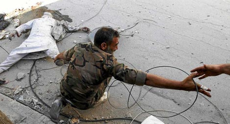 Un miembro del ejército arrastra un cadáver en Alepo. | AFP