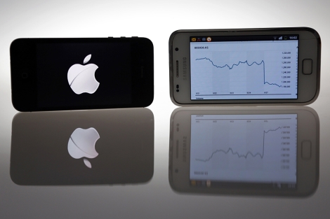 Un IPhone 4S y un Samsung Galaxy S con la grfica de la cada en bolsa.| Reuters
