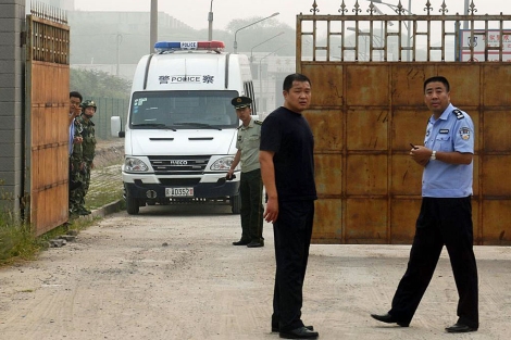 Los policas esperan la salida del disidente Wang Xiaoning este viernes. | Afp