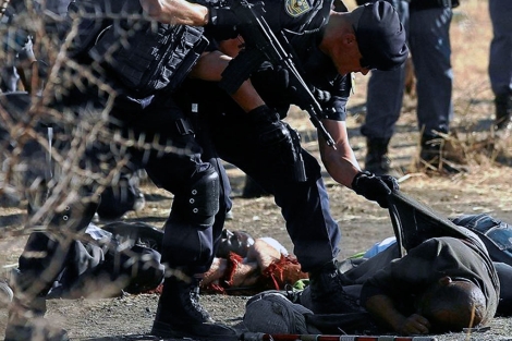 Un polica examina uno de los cadveres de los mineros. | Reuters